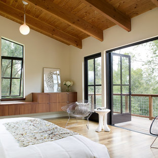 Example of a large trendy master light wood floor bedroom design in San Francisco with beige walls and no fireplace