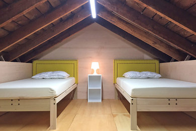 Imagen de dormitorio tipo loft moderno pequeño con suelo de madera clara