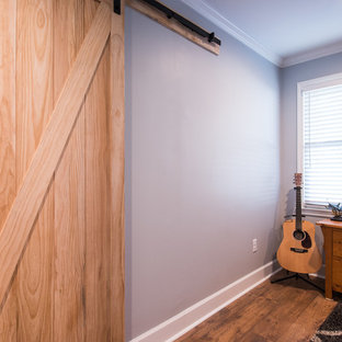 Aménagement d'une chambre d'amis campagne de taille moyenne avec un mur gris, un sol en bois brun et aucune cheminée.