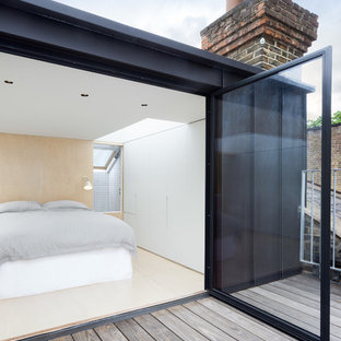 Modernes Hauptschlafzimmer mit weißer Wandfarbe und Sperrholzboden in London