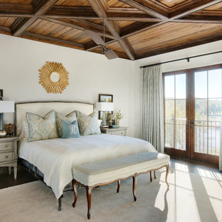 Modelo de dormitorio principal, costero, con paredes blancas, suelo de madera oscura y suelo marrón