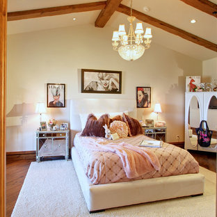 Ejemplo de dormitorio principal, mediterráneo, extra grande, con paredes beige, suelo de madera oscura, chimenea de doble cara, marco de chimenea de piedra y suelo marrón