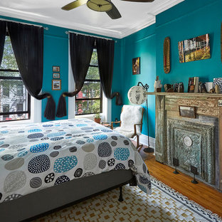 Foto de dormitorio principal, bohemio, de tamaño medio, con paredes azules, suelo de madera en tonos medios, chimeneas suspendidas y marco de chimenea de metal