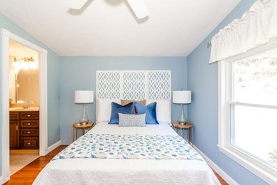 グランドラピッズにある小さなトラディショナルスタイルのおしゃれな寝室 (青い壁、無垢フローリング、茶色い床) のインテリア
