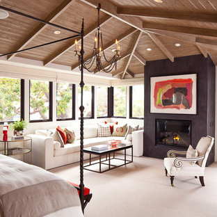 Modelo de dormitorio principal, mediterráneo, grande, con moqueta, marco de chimenea de yeso, paredes blancas y chimenea tradicional