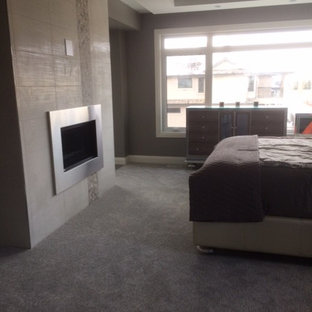 Foto de dormitorio principal, actual, de tamaño medio, con paredes grises, moqueta, chimeneas suspendidas, marco de chimenea de metal y suelo gris