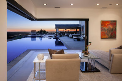 This is an example of an expansive modern master bedroom in Orange County with beige walls, porcelain flooring and a standard fireplace.