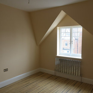 Foto de dormitorio tipo loft, contemporáneo, de tamaño medio, sin chimenea, con paredes beige, suelo marrón y suelo de bambú