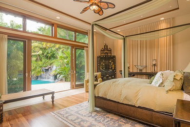 Inspiration för ett tropiskt sovrum, med beige väggar och mellanmörkt trägolv