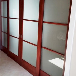 Modelo de habitación de invitados tropical, de tamaño medio, sin chimenea, con paredes beige y suelo de baldosas de porcelana