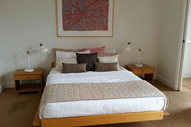Imagen de dormitorio principal actual de tamaño medio con paredes blancas