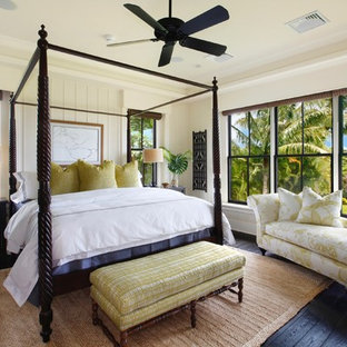 Foto de dormitorio tropical con paredes beige, suelo de madera oscura y suelo negro