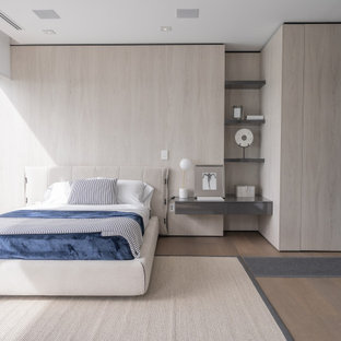 Modernes Schlafzimmer mit beiger Wandfarbe, braunem Holzboden, beigem Boden und Holzwänden in Miami