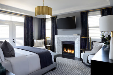 Стильный дизайн: спальня в стиле неоклассика (современная классика) с серыми стенами, темным паркетным полом, стандартным камином, фасадом камина из камня и коричневым полом - последний тренд