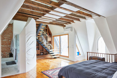 Diseño de dormitorio principal contemporáneo grande sin chimenea con paredes blancas, suelo de madera en tonos medios y suelo marrón