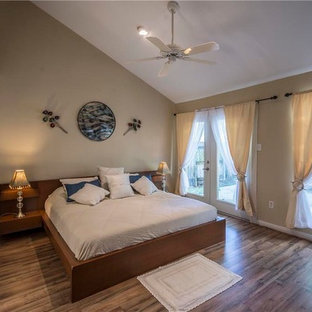 Modelo de habitación de invitados actual, de tamaño medio, con paredes amarillas, moqueta, chimenea de doble cara y marco de chimenea de ladrillo
