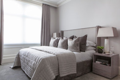 This is an example of a classic grey and white bedroom in London with grey walls and carpet.