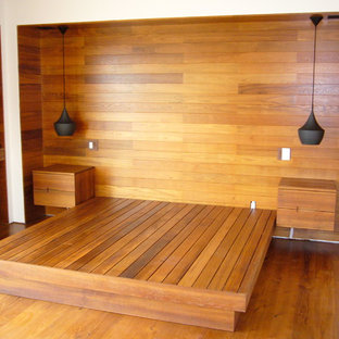 Foto de habitación de invitados moderna, grande, con paredes marrones y suelo de madera clara