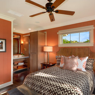 Modelo de dormitorio principal, exótico, con parades naranjas y suelo de madera oscura