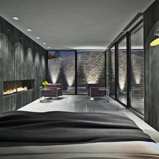 Imagen de dormitorio principal, minimalista, con paredes negras, suelo de madera pintada, chimenea lineal, marco de chimenea de madera y suelo blanco