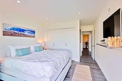 Diseño de habitación de invitados costera grande sin chimenea con paredes blancas y suelo de baldosas de cerámica