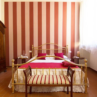 Imagen de habitación de invitados tradicional con paredes multicolor y suelo de baldosas de terracota