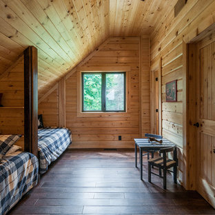 Ejemplo de dormitorio tipo loft, rural, de tamaño medio, con paredes marrones y suelo de madera en tonos medios