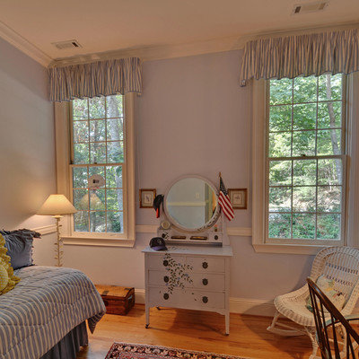 Elegant medium tone wood floor and orange floor bedroom photo in Atlanta with blue walls