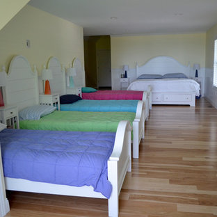 Imagen de habitación de invitados costera con paredes amarillas y suelo de madera clara
