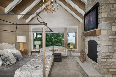 Ejemplo de dormitorio principal clásico con paredes beige, moqueta, marco de chimenea de piedra y suelo beige