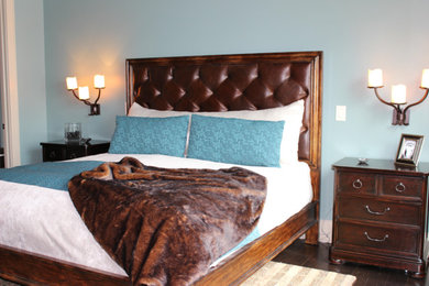 Modelo de dormitorio principal clásico de tamaño medio sin chimenea con paredes azules, suelo de madera oscura y suelo marrón
