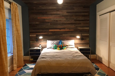 Immagine di una grande camera degli ospiti tradizionale con pareti blu, pavimento in legno massello medio, nessun camino e pavimento marrone