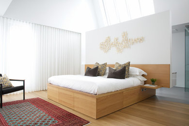 Modernes Schlafzimmer mit weißer Wandfarbe und hellem Holzboden in Calgary