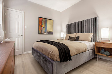 Foto de habitación de invitados moderna de tamaño medio con paredes grises y suelo de madera clara