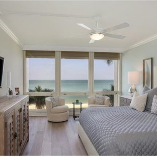 Foto de dormitorio principal, marinero, pequeño, con paredes azules y suelo de madera clara