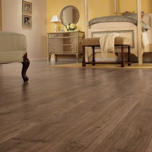 Diseño de habitación de invitados clásica, grande, con paredes amarillas y suelo de madera en tonos medios