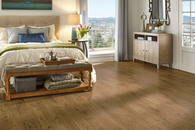 Example of a large transitional master medium tone wood floor and brown floor bedroom design in Other with beige walls and no fireplace