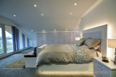 Photo of a large contemporary master bedroom in Manchester with carpet.