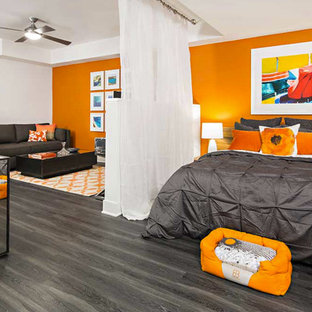 Modelo de dormitorio minimalista, pequeño, con parades naranjas y suelo de madera oscura