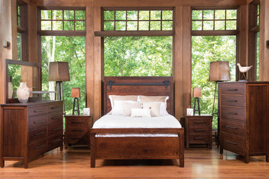 Imagen de dormitorio principal tradicional de tamaño medio con paredes marrones, suelo de madera en tonos medios y suelo marrón