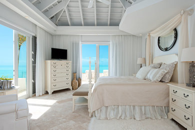 Imagen de dormitorio principal tropical sin chimenea con paredes blancas