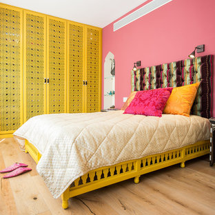 Modelo de dormitorio de estilo zen con paredes rosas y suelo de madera clara