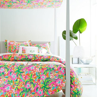 Immagine di una camera da letto tropicale con pareti bianche e pavimento in legno verniciato