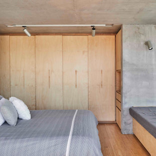 Réalisation d'une chambre parentale minimaliste de taille moyenne avec un sol en bambou, un mur gris et un sol beige.