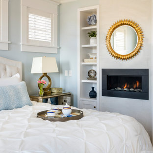 Immagine di una camera da letto stile marinaro con pareti blu e camino lineare Ribbon