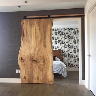Foto de dormitorio principal, rural, grande, sin chimenea, con paredes multicolor, suelo de madera en tonos medios y suelo gris