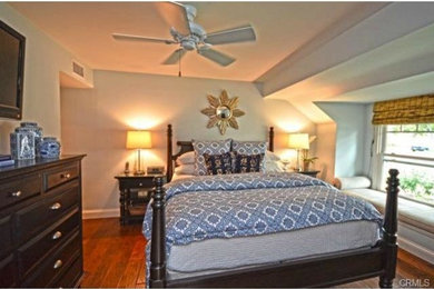 Inspiration for a mid-sized coastal master medium tone wood floor bedroom remodel in Orange County with blue walls