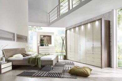 Modelo de dormitorio tipo loft minimalista grande sin chimenea con paredes blancas, suelo de baldosas de cerámica y suelo beige