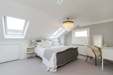 This is an example of a contemporary master bedroom in London with carpet.