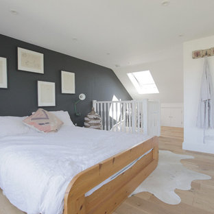 Photo of a medium sized contemporary master bedroom in London with grey walls, light hardwood flooring and beige floors.
